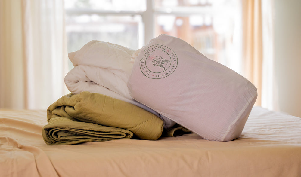 organic cotton lightweight all-season comforters in natural storage bag, styled on a bed in a naturally minded home