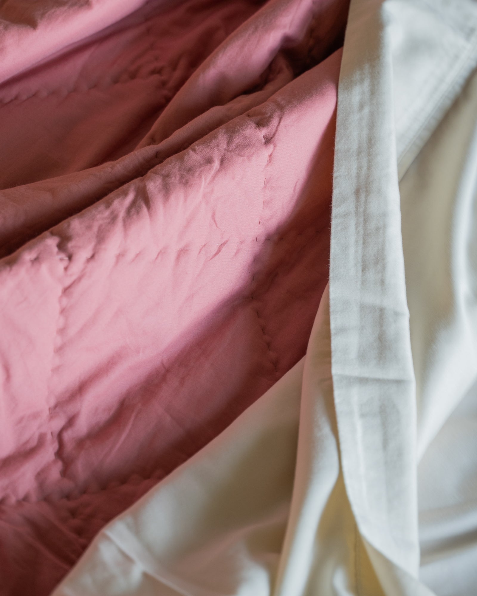 Close-up of organic cambric cotton weave and hand-finished stitching